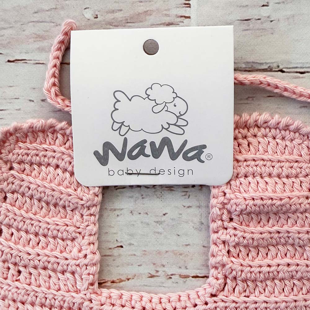 Babero rosado de crochet con etiqueta de marca y bordes redondeados