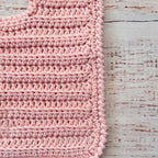 Babero de crochet rosado en vista del tejido con puntos en relieve