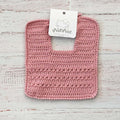 Babero de crochet palo rosa con etiqueta en la parte superior