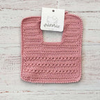 Babero de crochet palo rosa con etiqueta en la parte superior
