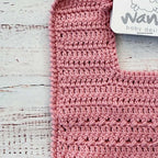 Babero de crochet palo rosa con etiqueta y borde superior