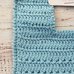 Babero de crochet celeste con tejido en relieve y patrón de punto