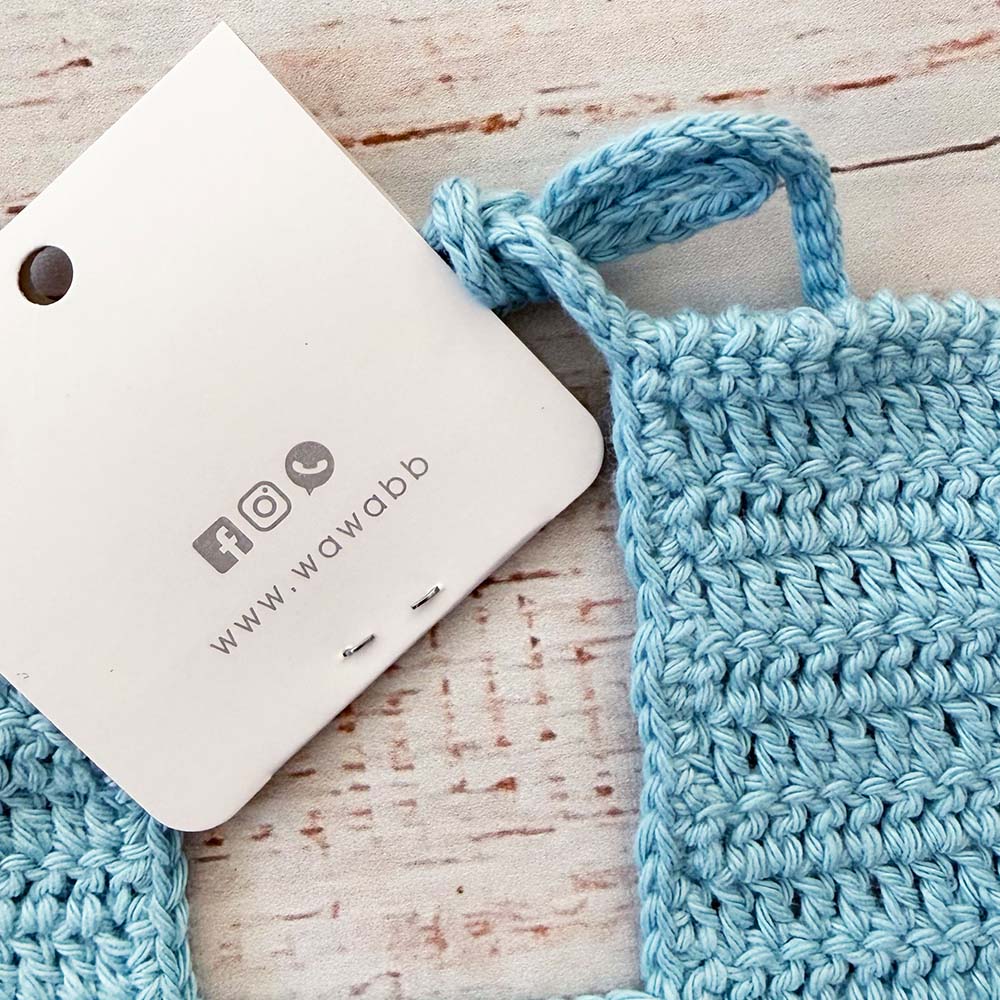 Babero de crochet celeste con borde grueso y asa trasera para sujetar