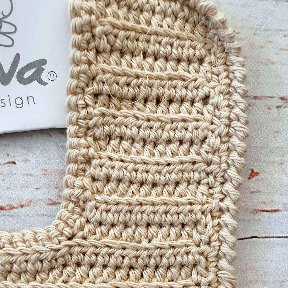 Babero de ganchillo beige con tejido en puntos y relieve, vista de detalle