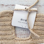 Babero de ganchillo beige con cinta superior para anudar y etiqueta colgante