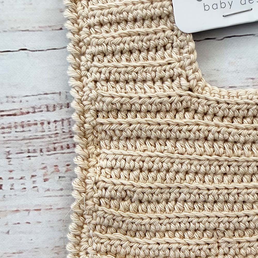 Babero de ganchillo beige con filas de puntos y borde inferior ancho