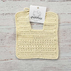 Babero de crochet color crema con bordes redondeados y asa para sujetar al cuello