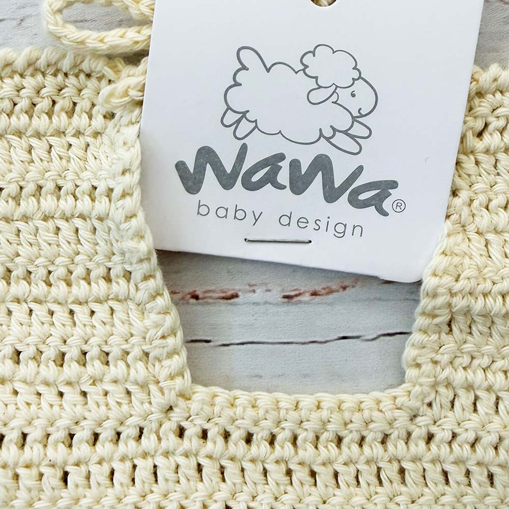 Babero de crochet crema con etiqueta Wana baby design en el centro