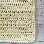 Babero de crochet crema con textura trenzada y patrón de punto cerrado