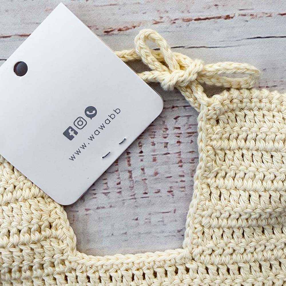 Babero de crochet crema con etiqueta colgante y cordón de sujeción