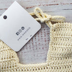 Babero de crochet crema con etiqueta colgante y cordón de sujeción