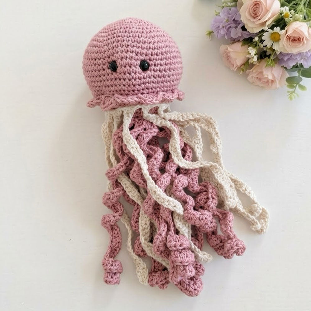 Medusa tejida a crochet rosa palo con múltiples tentáculos de hilo crudo