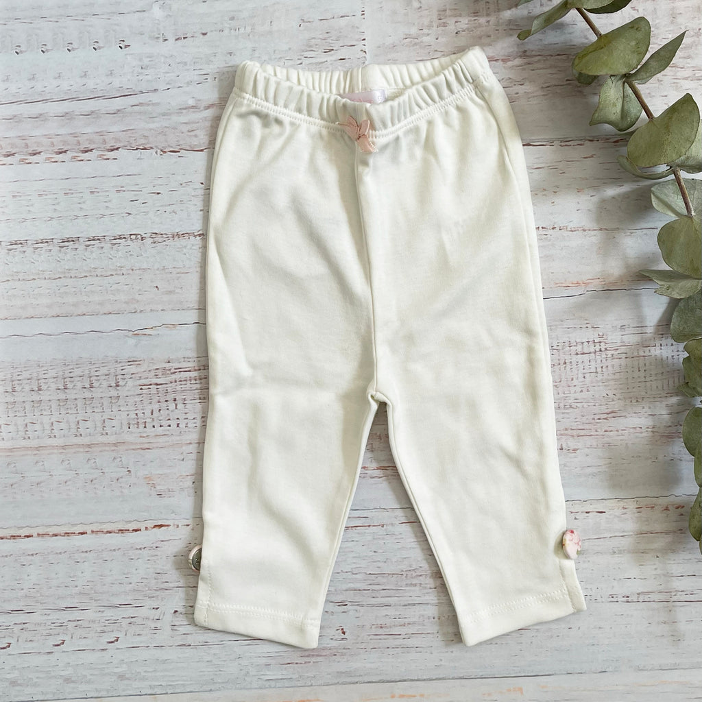 Leggings de algodón color crema con cintura elástica y botones decorativos en el lateral