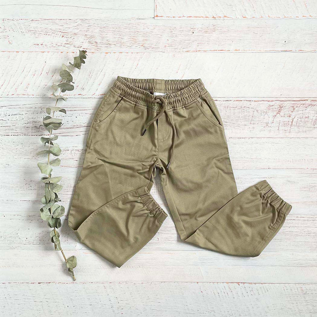 Pantalón dril beige con cintura elástica y cordón, bolsillos y pierna entallada