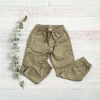 Pantalón dril beige con cintura elástica y cordón, bolsillos y pierna entallada